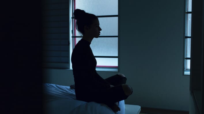 woman sits up awake in bedroom