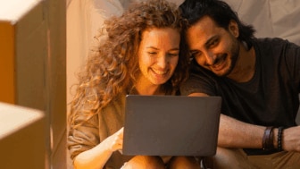 Couple laughing while looking at computer screen