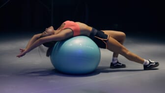 woman exercises on blue ball